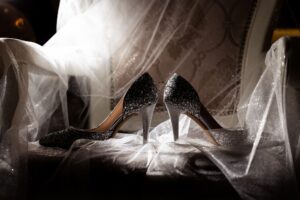 Bridal shoes with wedding ring and veil styled for wedding day details
