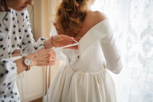 Bride getting measured during a wedding dress fitting for alterations