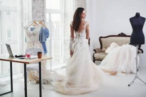 Bride standing in a wedding gown during a professional bridal fitting