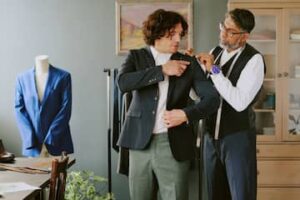 Tailor adjusting a client’s jacket during a fitting appointment