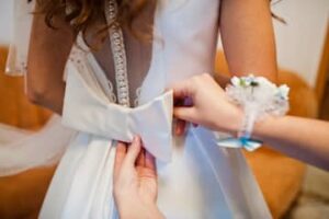 Seamstress pinning the back of a dress during a professional alteration fitting