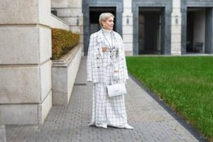 Woman wearing full-length tailored wide-leg trousers with a structured checked blazer