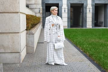 Woman wearing full-length tailored wide-leg trousers with a structured checked blazer