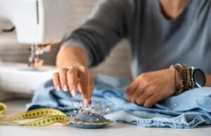 Close-up of professional alteration work with pins, fabric, and sewing tools